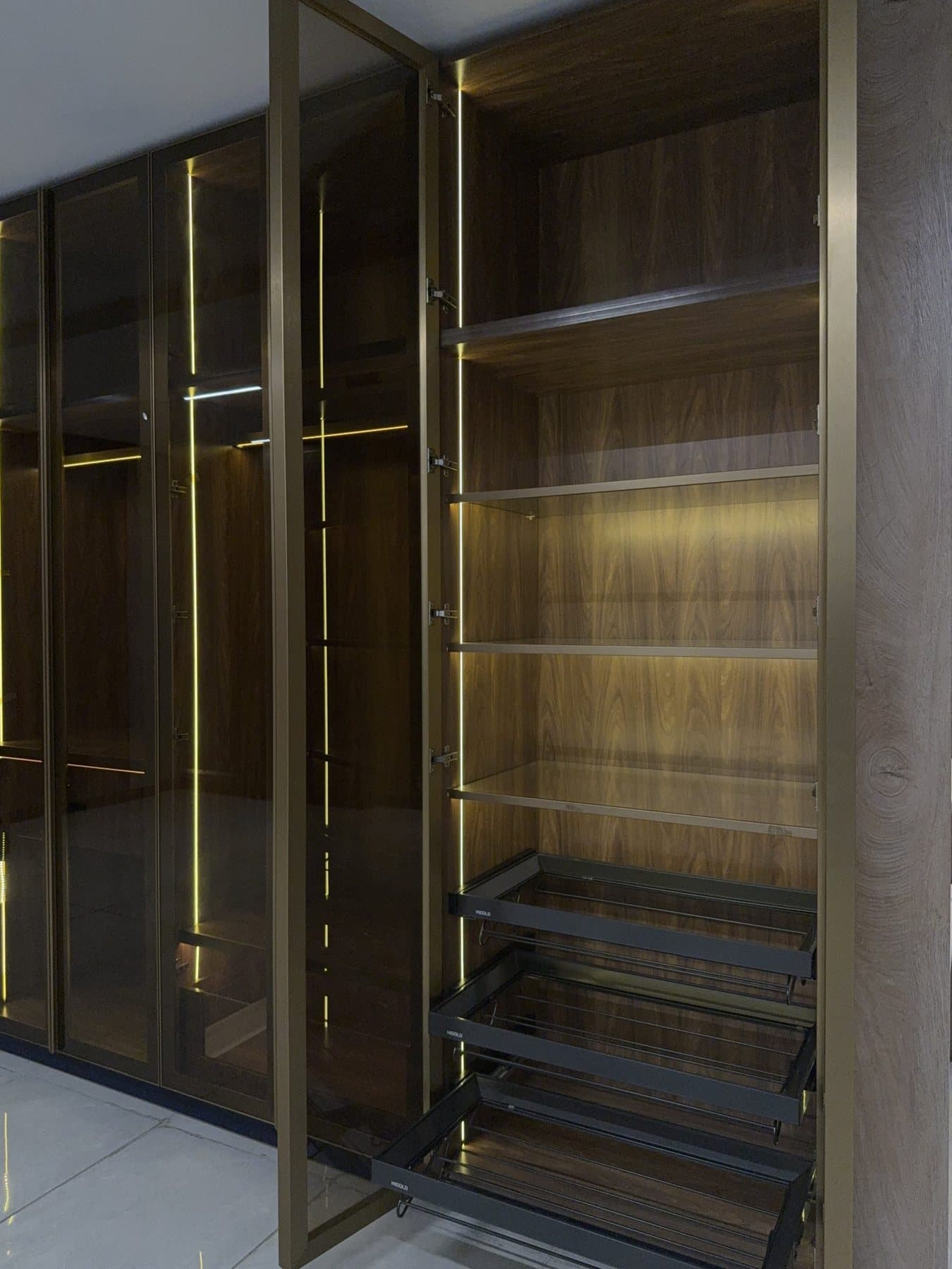Brass-framed glass wardrobe by Amaza Homes